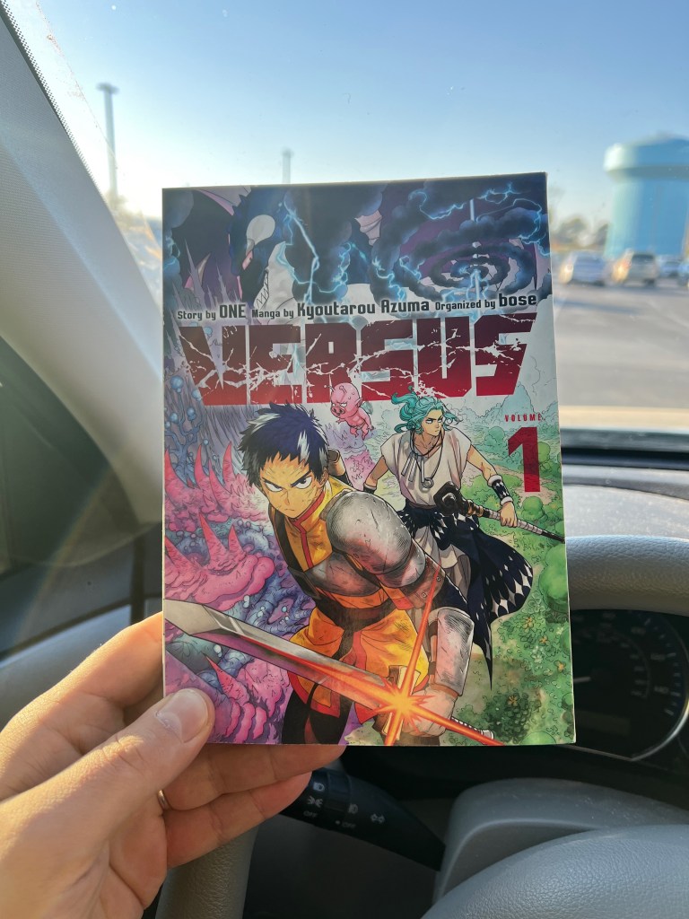 Photo of Volume 1 of Versus being held up